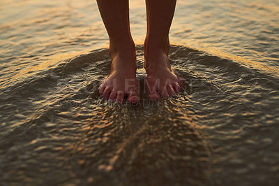 Buy stock photo Cropped shot of a woman standing with her feet in the water