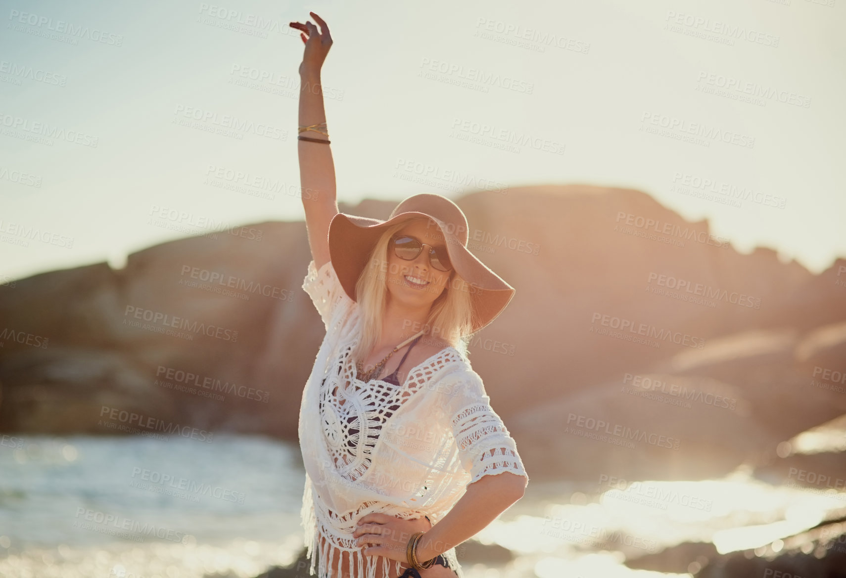 Buy stock photo Shot of a young woman on the beach with her hand in the air