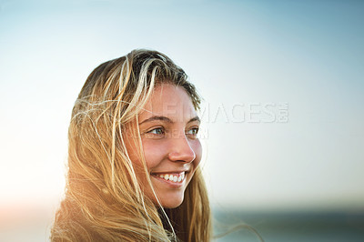 Buy stock photo Cropped shot of an attractive young female surfer standing on the beach