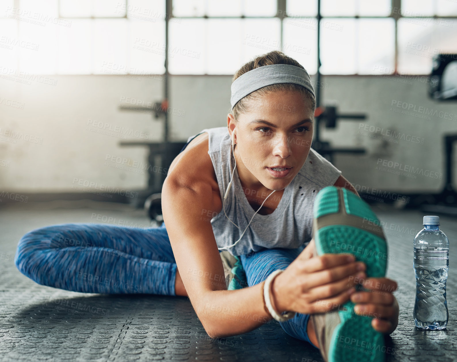 Buy stock photo Legs, music and stretching with woman on floor of gym for fitness, health or wellness. Exercise, training and warm up for workout, earphones and athlete getting ready for physical improvement routine