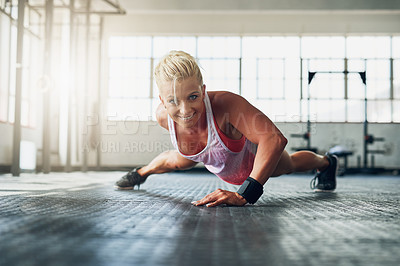 Buy stock photo Shot of a young attractive woman doing push ups with one hand at the gym