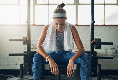 Buy stock photo Shot of a young attractive woman resting in a gym