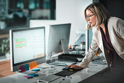 Buy stock photo Shot of a businesswoman editing a sheet on her computer