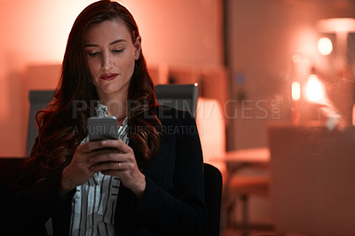 Buy stock photo Shot of a businesswoman using a mobile phone during a late night at work