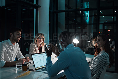 Buy stock photo Shot of colleagues having a meeting during a late night in a modern office