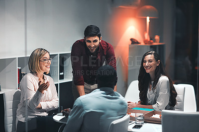 Buy stock photo Shot of colleagues having a meeting during a late night in a modern office
