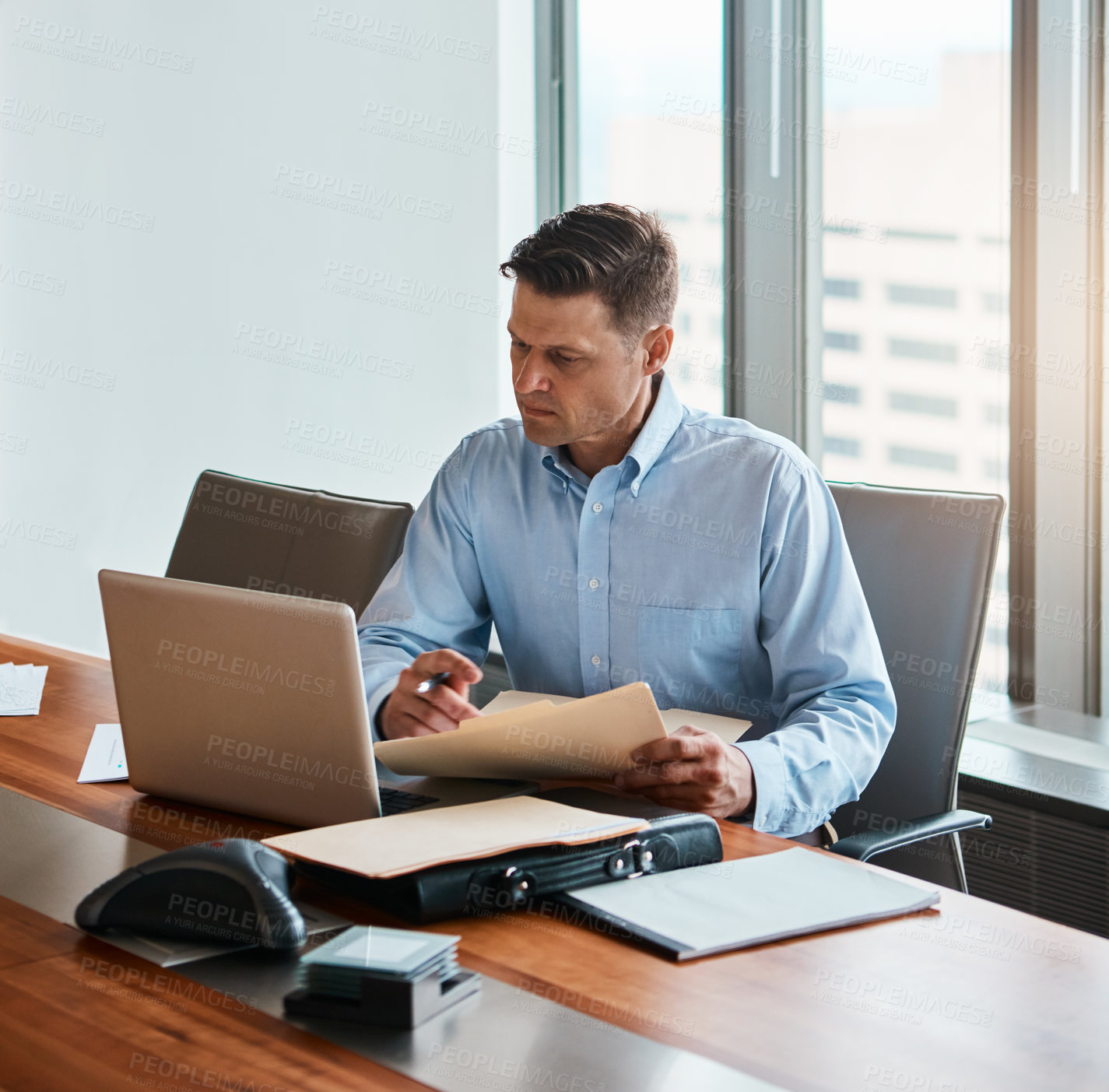 Buy stock photo Shot of a mature businessman working at his desk