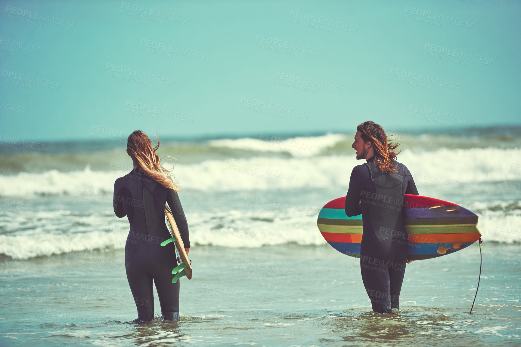 Buy stock photo Shot of a young couple surfing at the beach