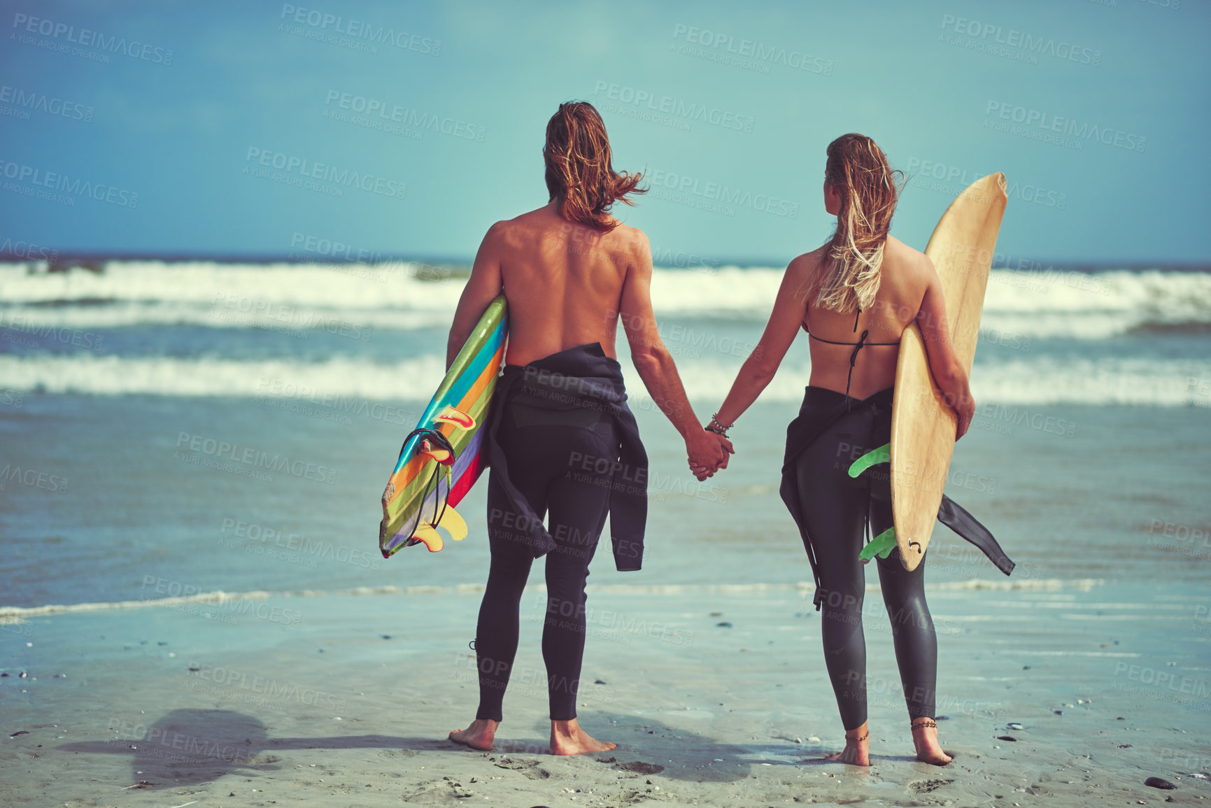 Buy stock photo Rearview shot of a young couple waiting for the perfect wave