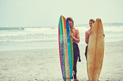 Buy stock photo Shot of a young couple spending the day out surfing