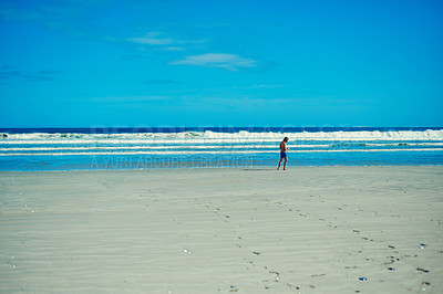 Buy stock photo Shot of a young man spending the day at the beach