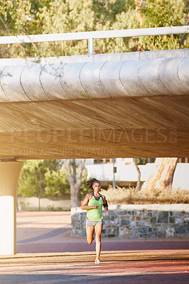 Buy stock photo Shot of a sporty young woman out for a run