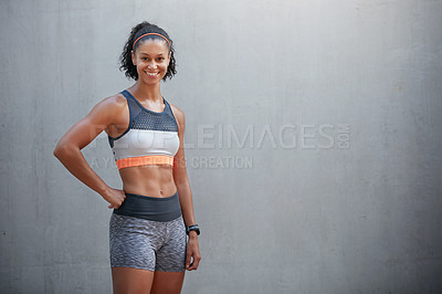 Buy stock photo Cropped portrait of a sporty young woman standing in front of a grey wall