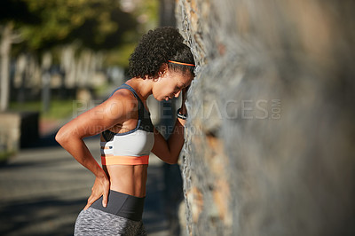 Buy stock photo Cropped shot of an attractive young woman looking exhausted after a run through the city