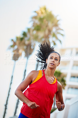 Buy stock photo Shot of a sporty young woman out running in the city by herself