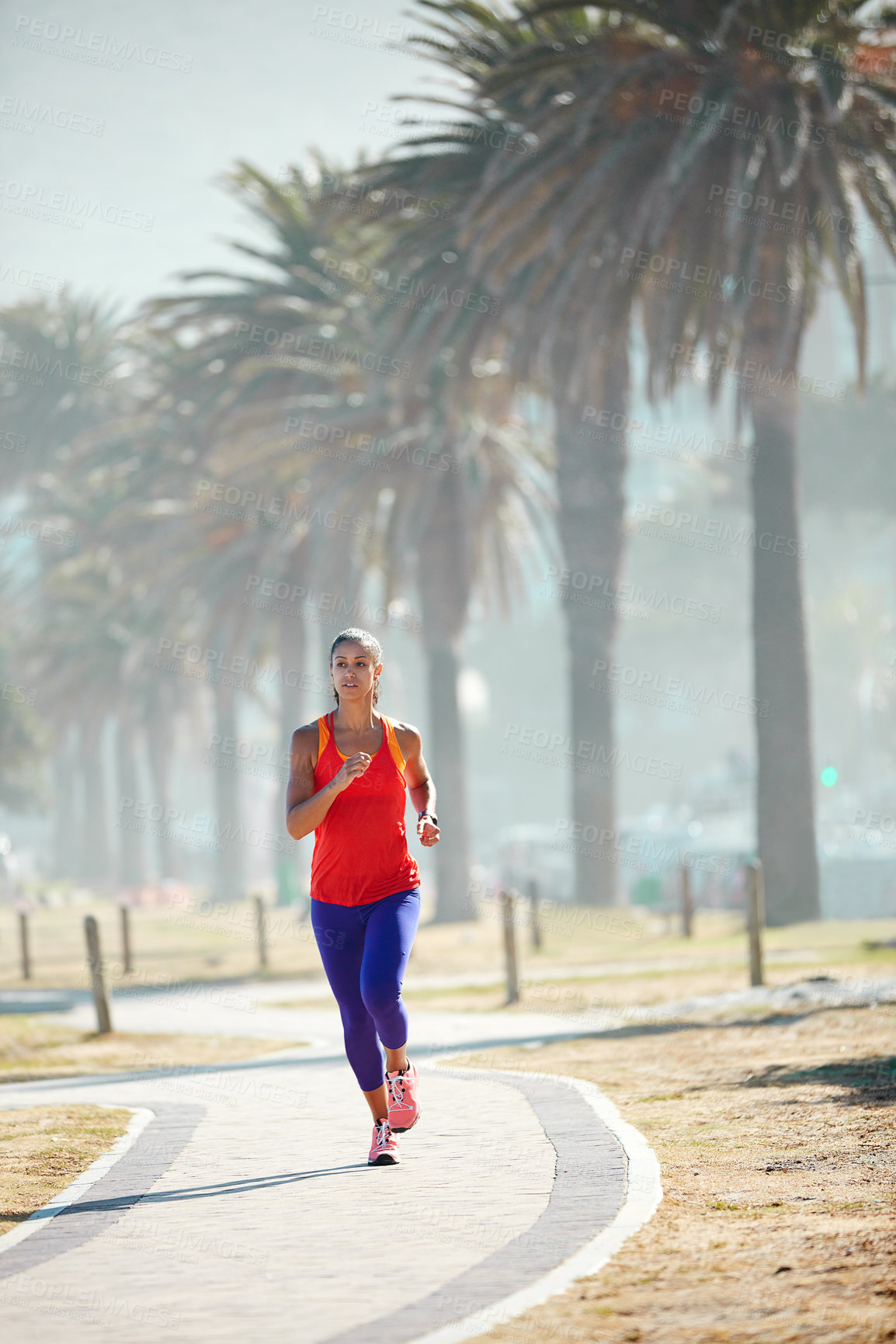 Buy stock photo Shot of a sporty young woman out running in the city by herself