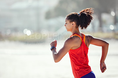 Buy stock photo Shot of a sporty young woman out at the beach for her morning run