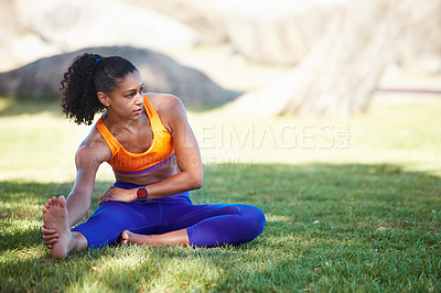 Buy stock photo Shot of a sporty young woman stretching before her workout
