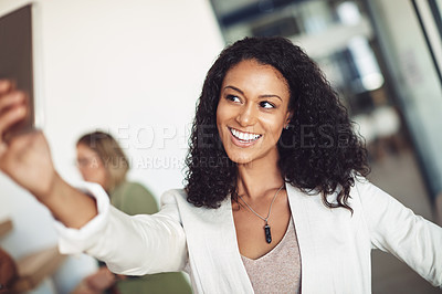 Buy stock photo Shot of a young businesswoman taking a selfie in the office