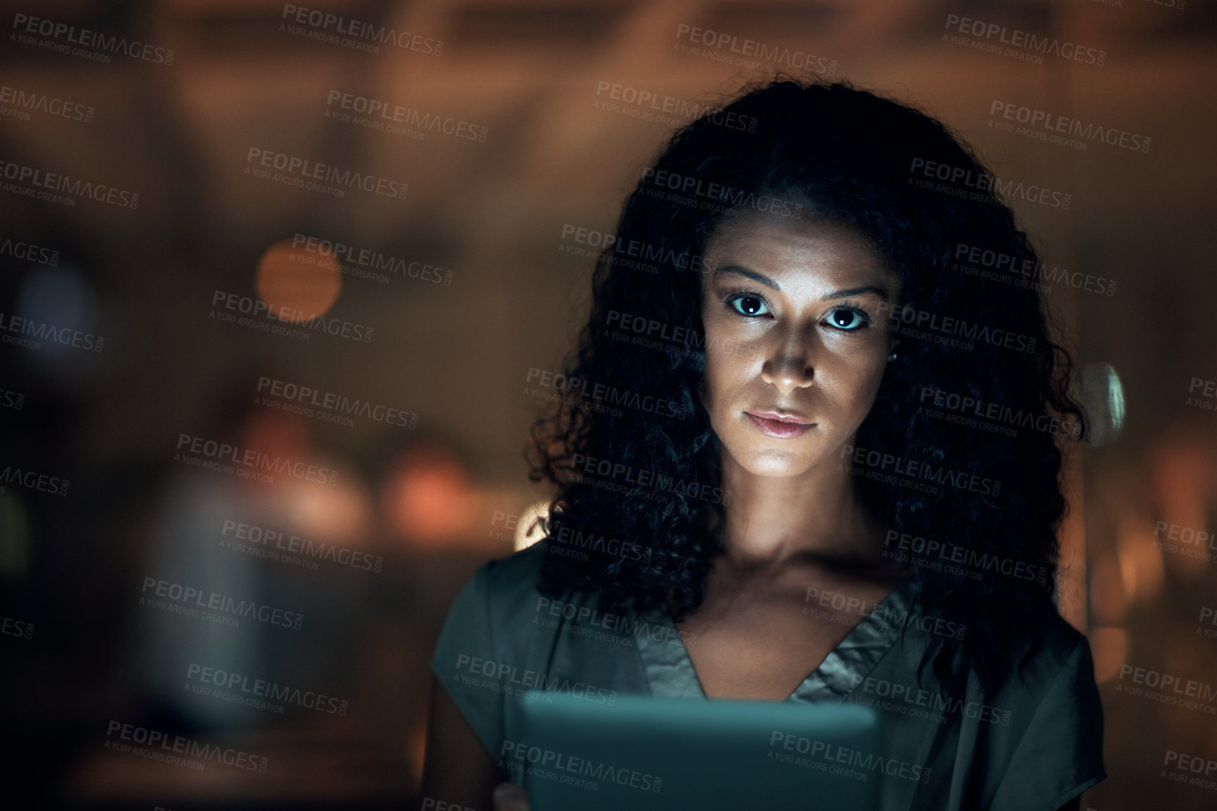 Buy stock photo Shot of a young businesswoman using a digital tablet during a late night at work