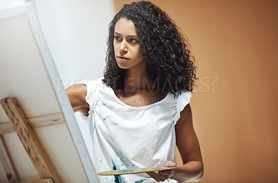 Buy stock photo Shot of an attractive young woman painting on a canvas at home