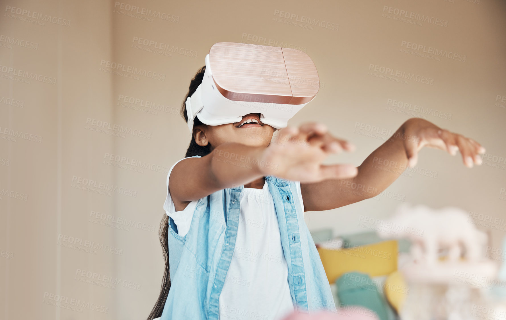 Buy stock photo Shot of a young girl using a virtual reality headset at home