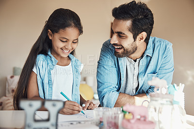 Buy stock photo Shot of a cute young girl and her father drawing on paper together at home