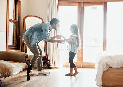 Buy stock photo Shot of a happy father and daughter dancing together at home