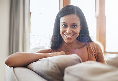 Buy stock photo Shot of a happy young woman enjoying a relaxing day on the sofa at home