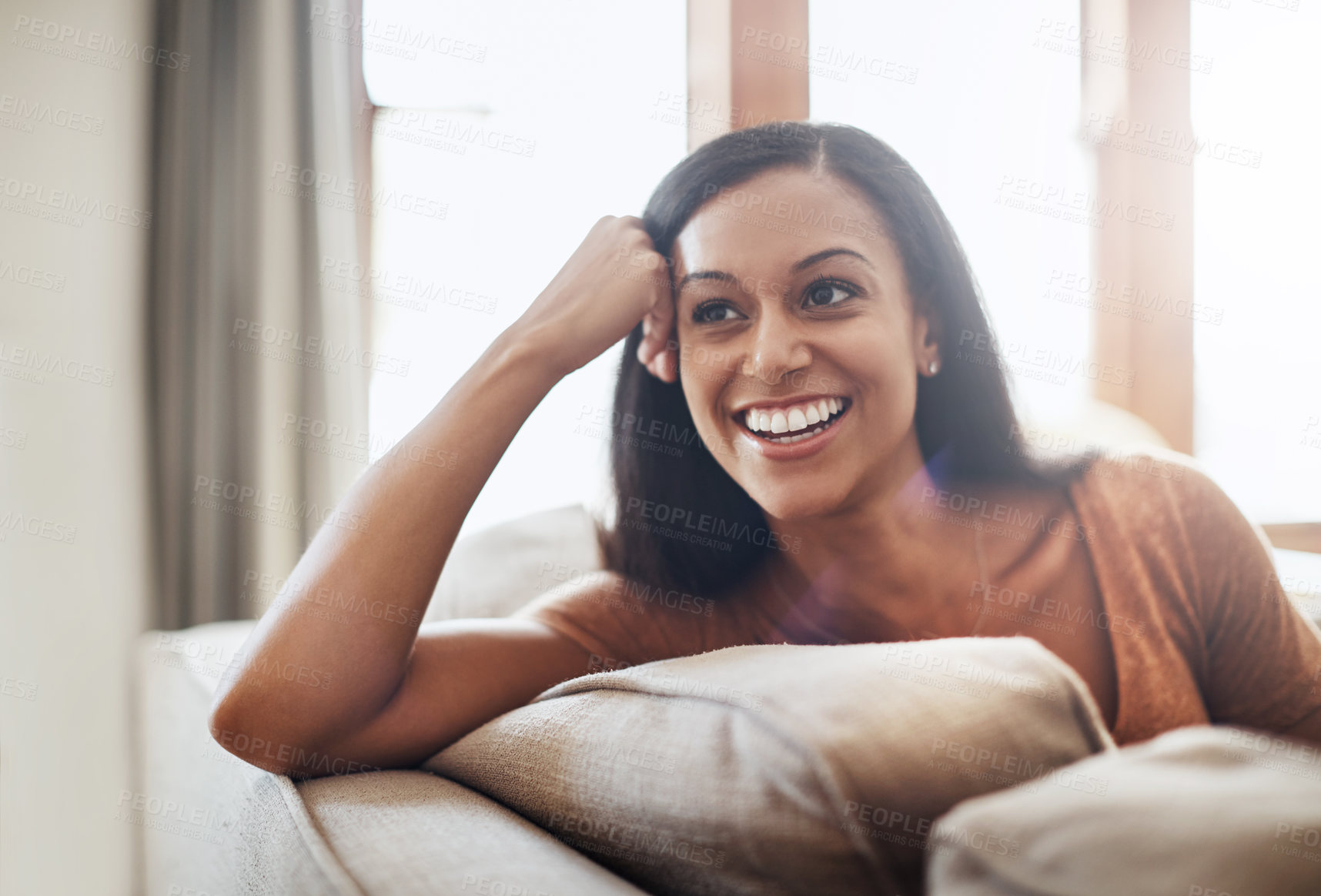 Buy stock photo Shot of a happy young woman enjoying a relaxing day on the sofa at home