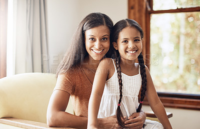 Buy stock photo Shot of a happy mother and daughter relaxing together on the sofa at home