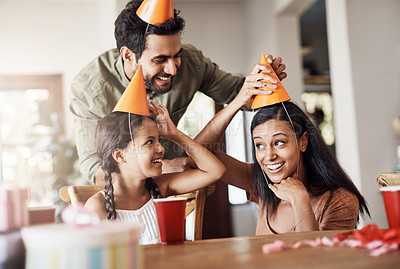 Buy stock photo Shot of a happy mother and father celebrating their daughter’s birthday at home