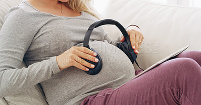 Buy stock photo Shot of an unrecognizable pregnant woman playing music for her baby at home