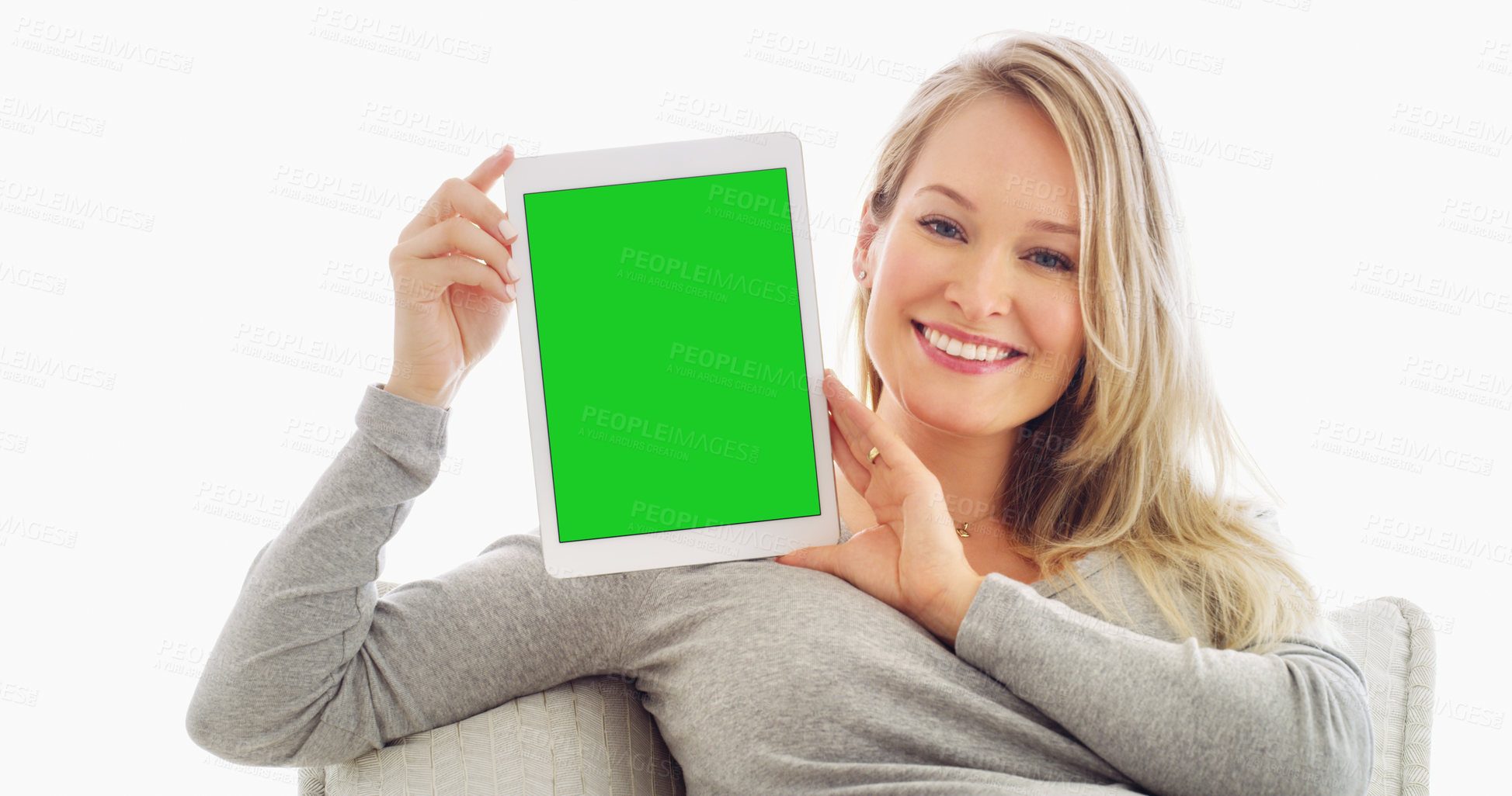 Buy stock photo Shot of an attractive young woman holding up a tablet at home