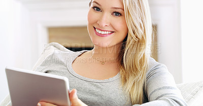 Buy stock photo Cropped portrait of an attractive young woman using a tablet at home