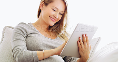 Buy stock photo Shot of a pregnant woman using a tablet at home