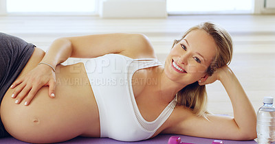 Buy stock photo Cropped portrait of an attractive young pregnant woman lying on her side on a yoga mat