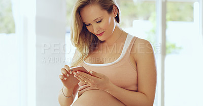 Buy stock photo Shot of a pregnant woman using a cellphone at home