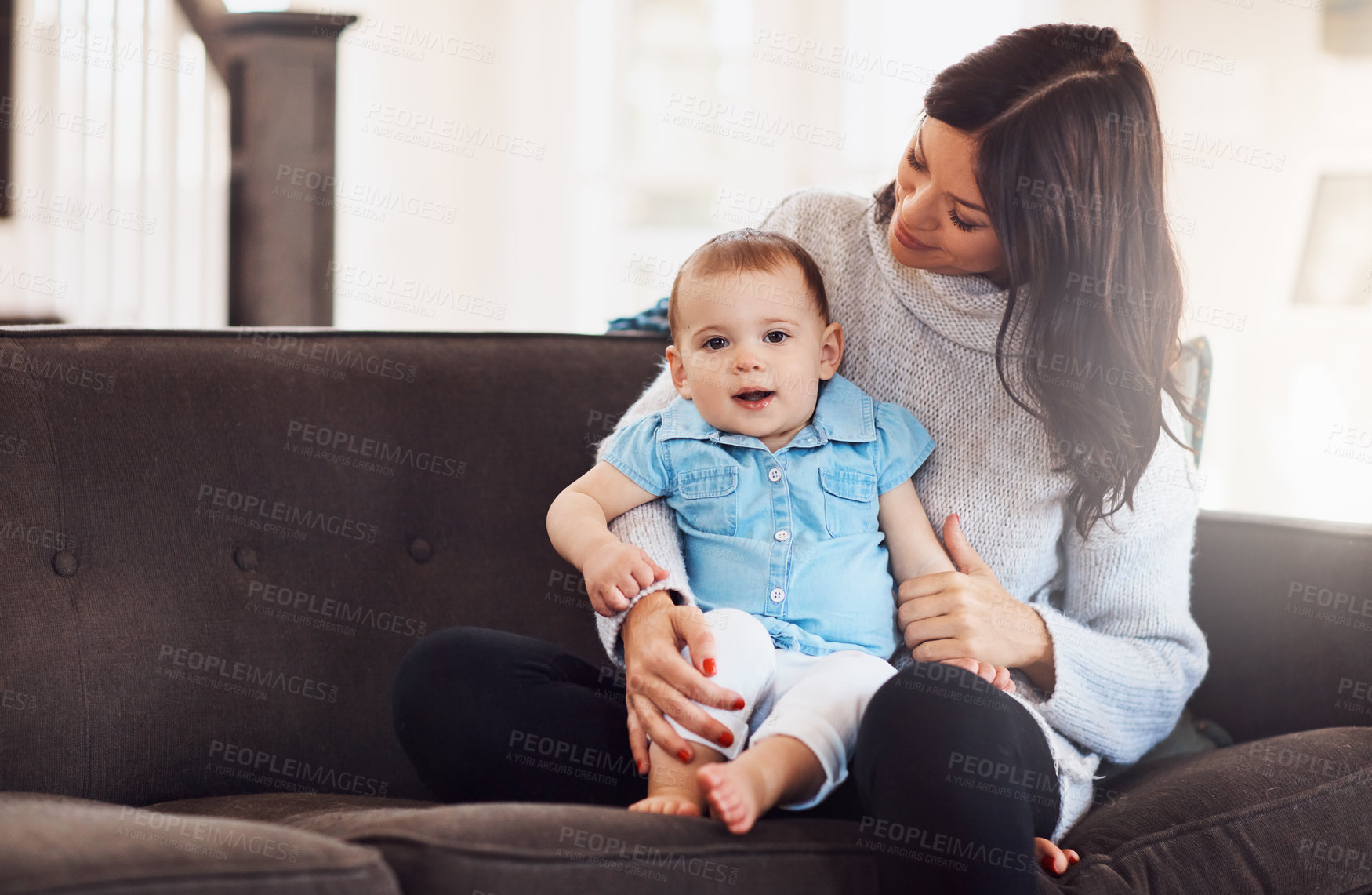 Buy stock photo Family, mother and baby on sofa in living room, holding hands for love and embrace for support. Smile, motherhood and toddler with woman together, hug and play by sitting for relationship at home