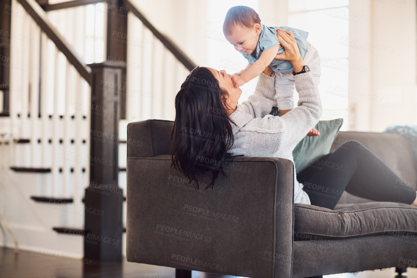 Buy stock photo Shot of an adorable baby girl bonding with her mother on the sofa at home