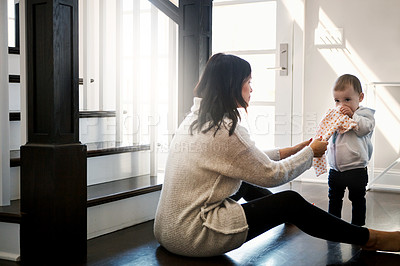 Buy stock photo Shot of a young woman trying to remove a cloth from her daughter