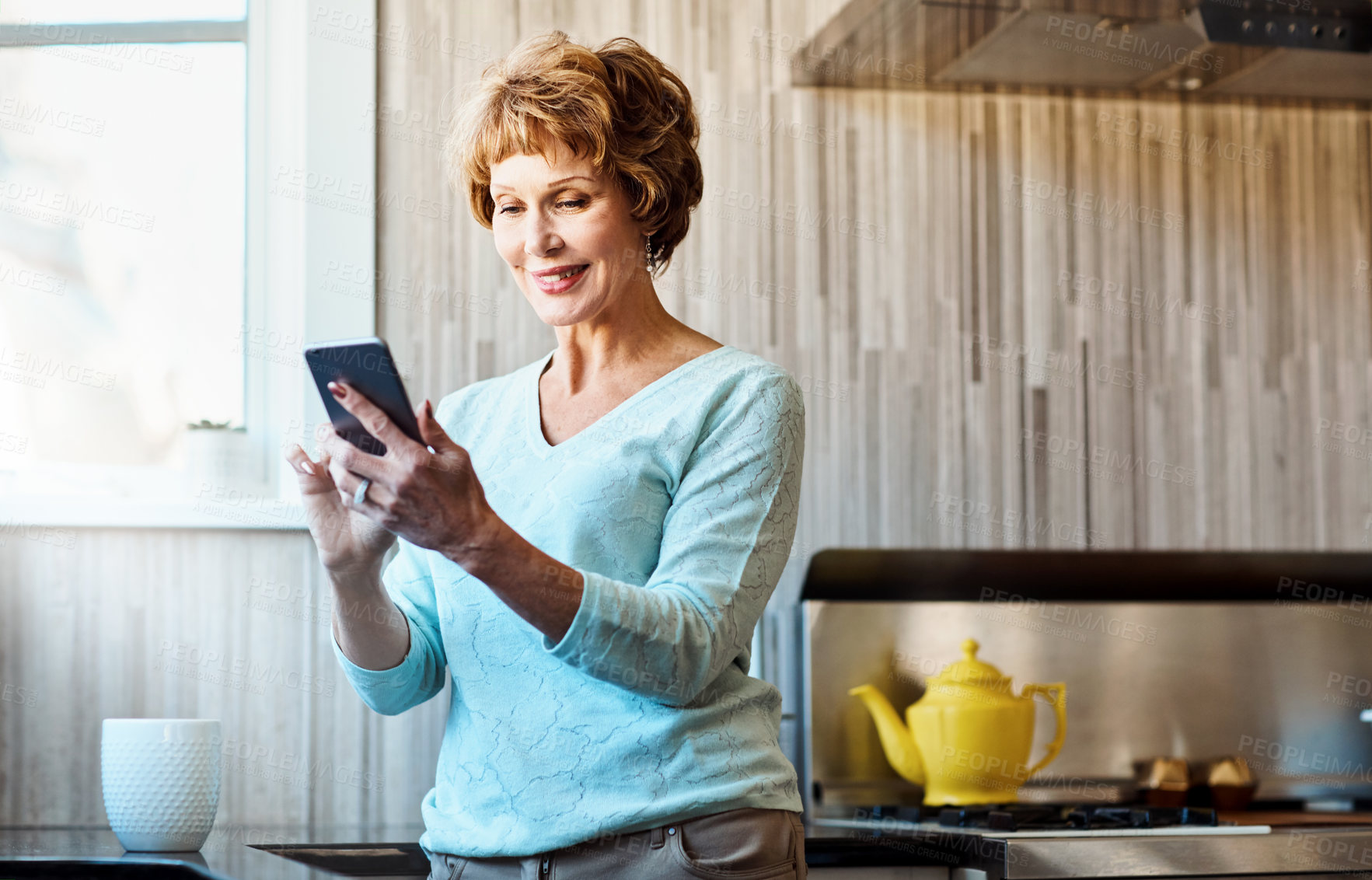 Buy stock photo Smartphone, smile and senior woman in kitchen with smile, connection or scroll on social media. Morning, relax and happy elderly person in home with phone, online chat or mobile app for communication