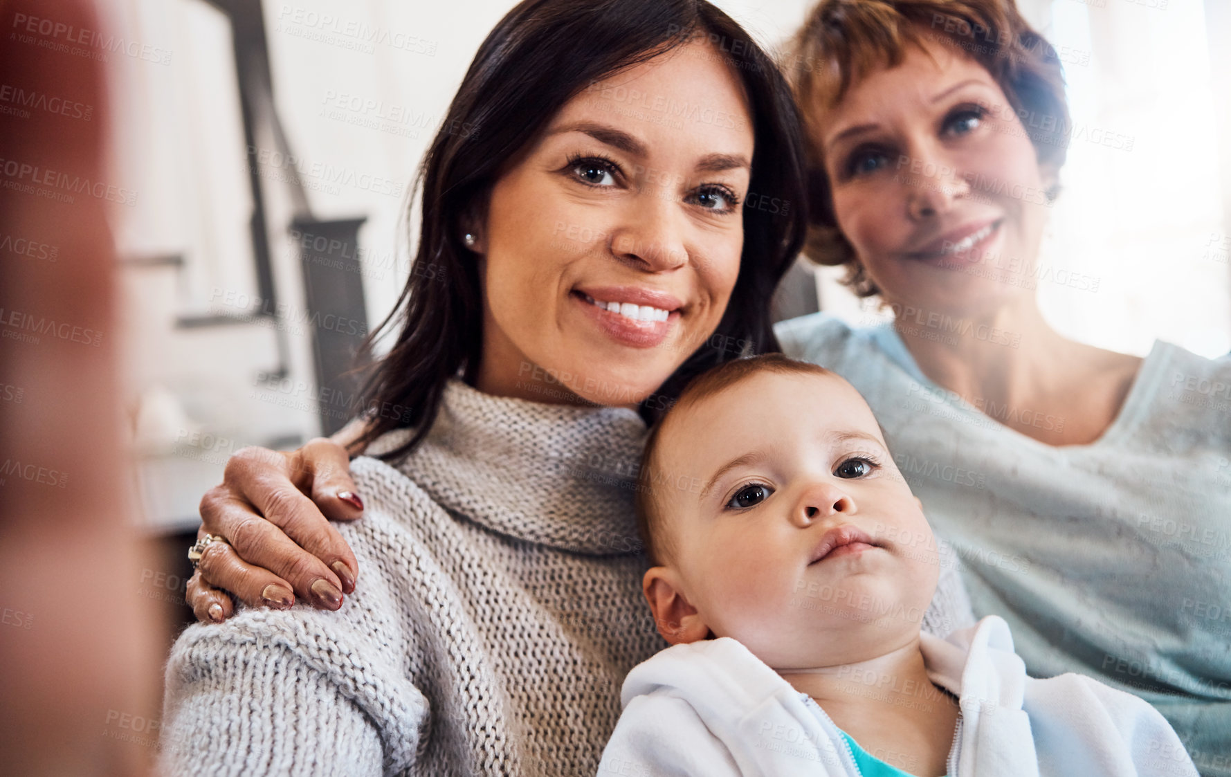 Buy stock photo Shot of a young woman taking selfies with her baby girl and mother at home