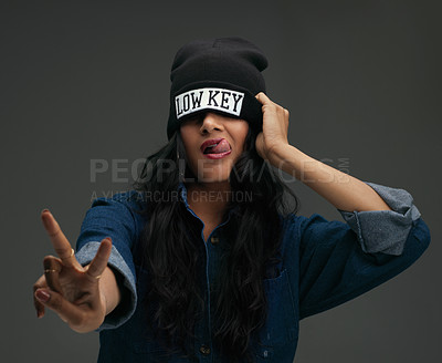 Buy stock photo Studio shot of a young woman in urban wear posing against a dark background