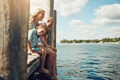 Buy stock photo Shot of a young family on a pier while out by the lake