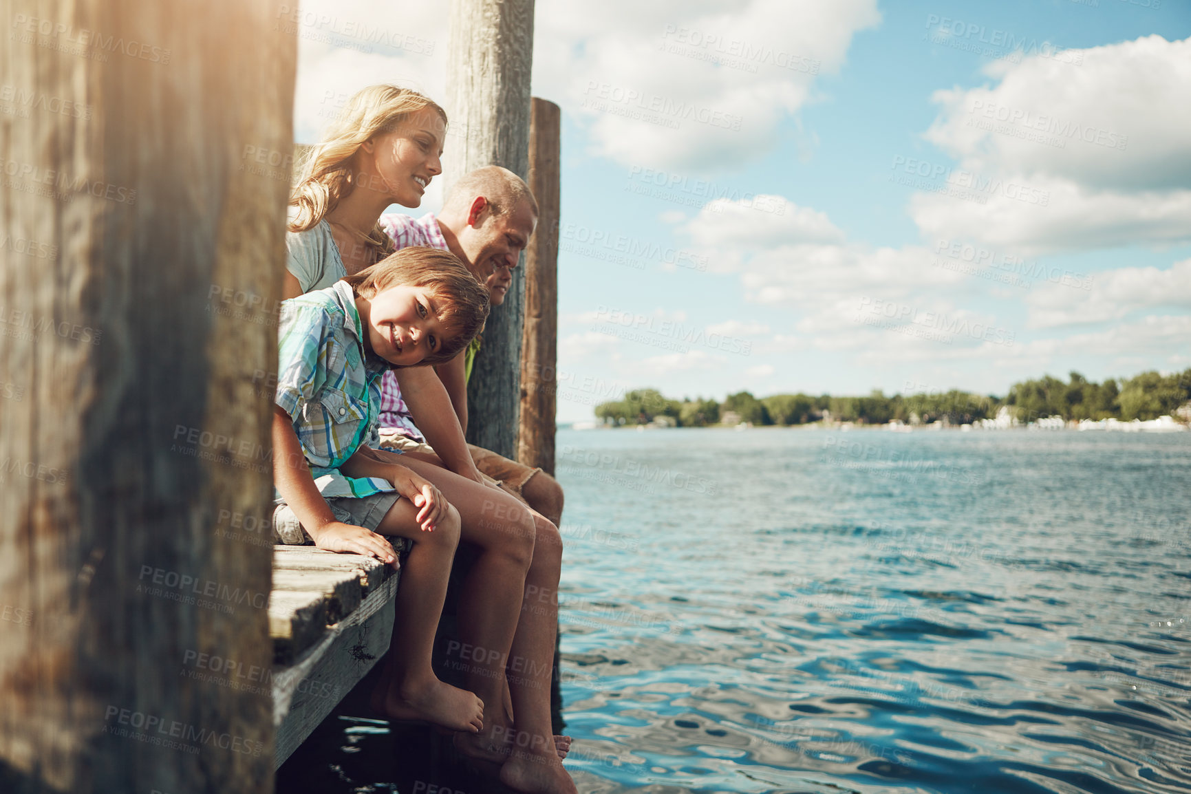 Buy stock photo Shot of a young family on a pier while out by the lake