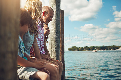 Buy stock photo Shot of a young family on a pier while out by the lake