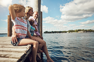 Buy stock photo Shot of a young family on a pier while out by the lake