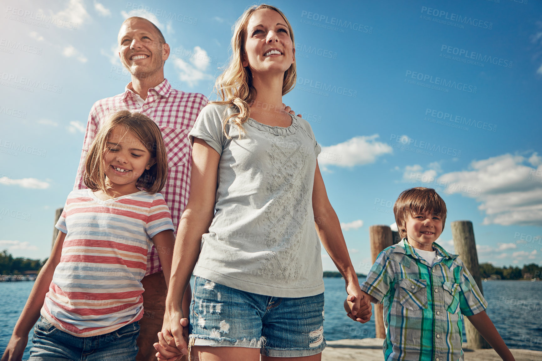 Buy stock photo Shot of a young family on a pier while out by the lake