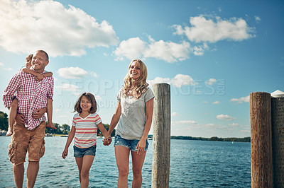 Buy stock photo Shot of a young family on a pier while out by the lake